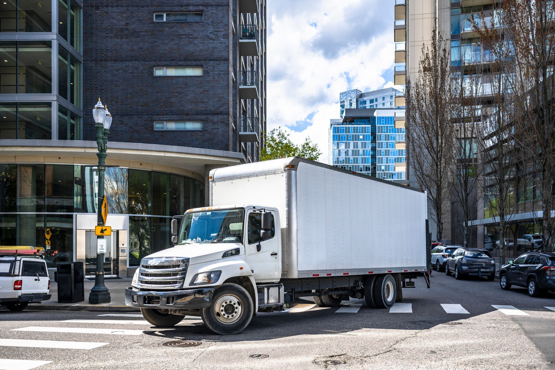 Un camion blanc roule dans une rue de la ville.
