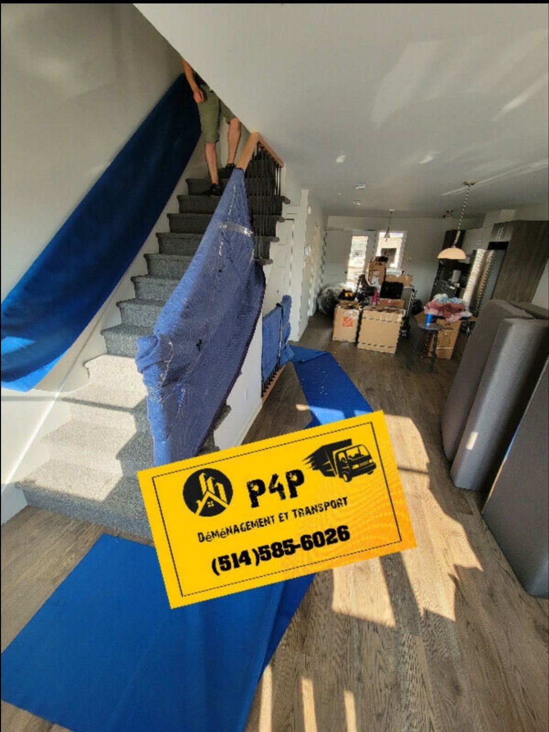A person is carrying a blue blanket up a set of stairs.