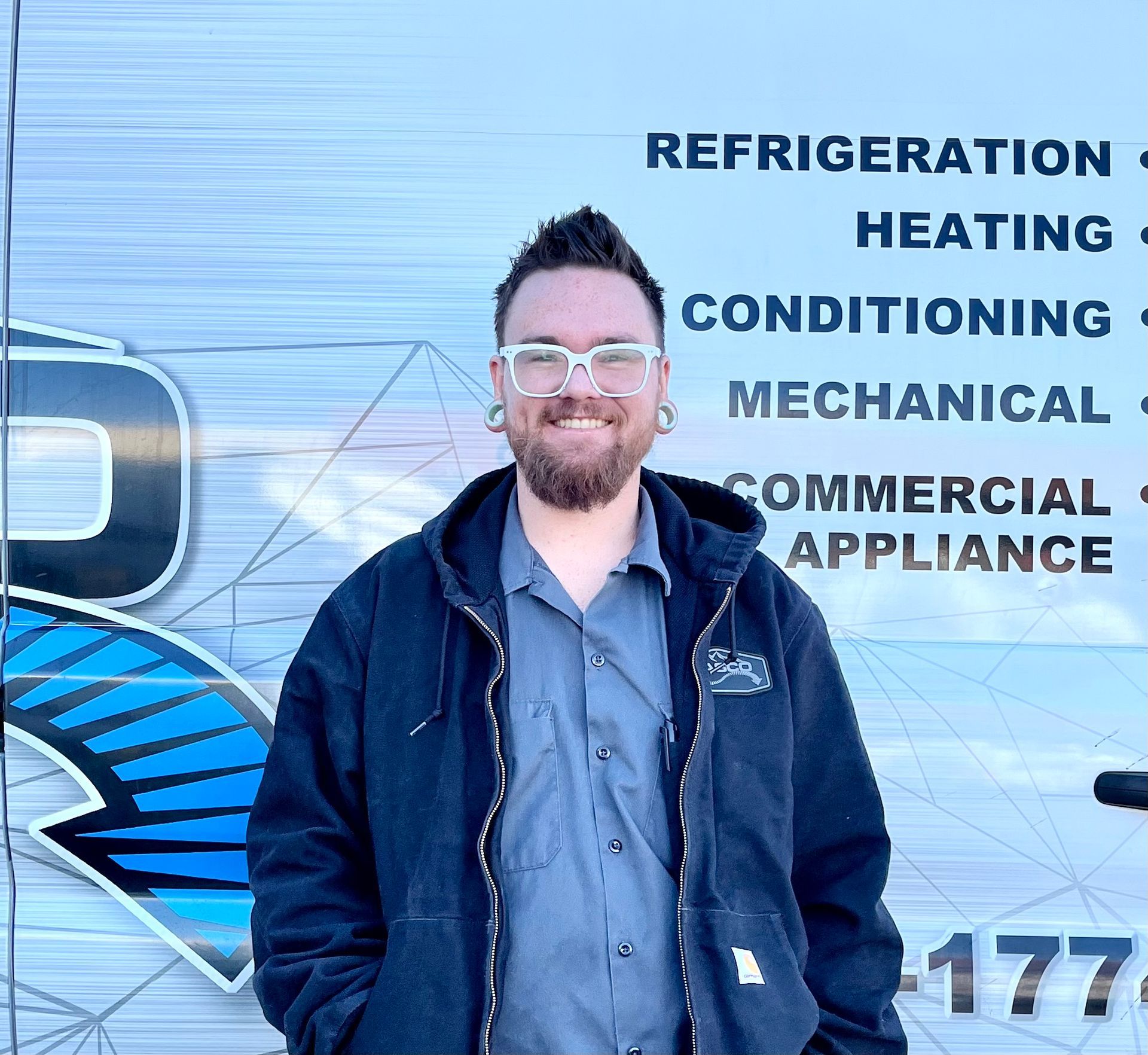 A man standing in front of a sign that says refrigeration heating conditioning mechanical commercial appliance