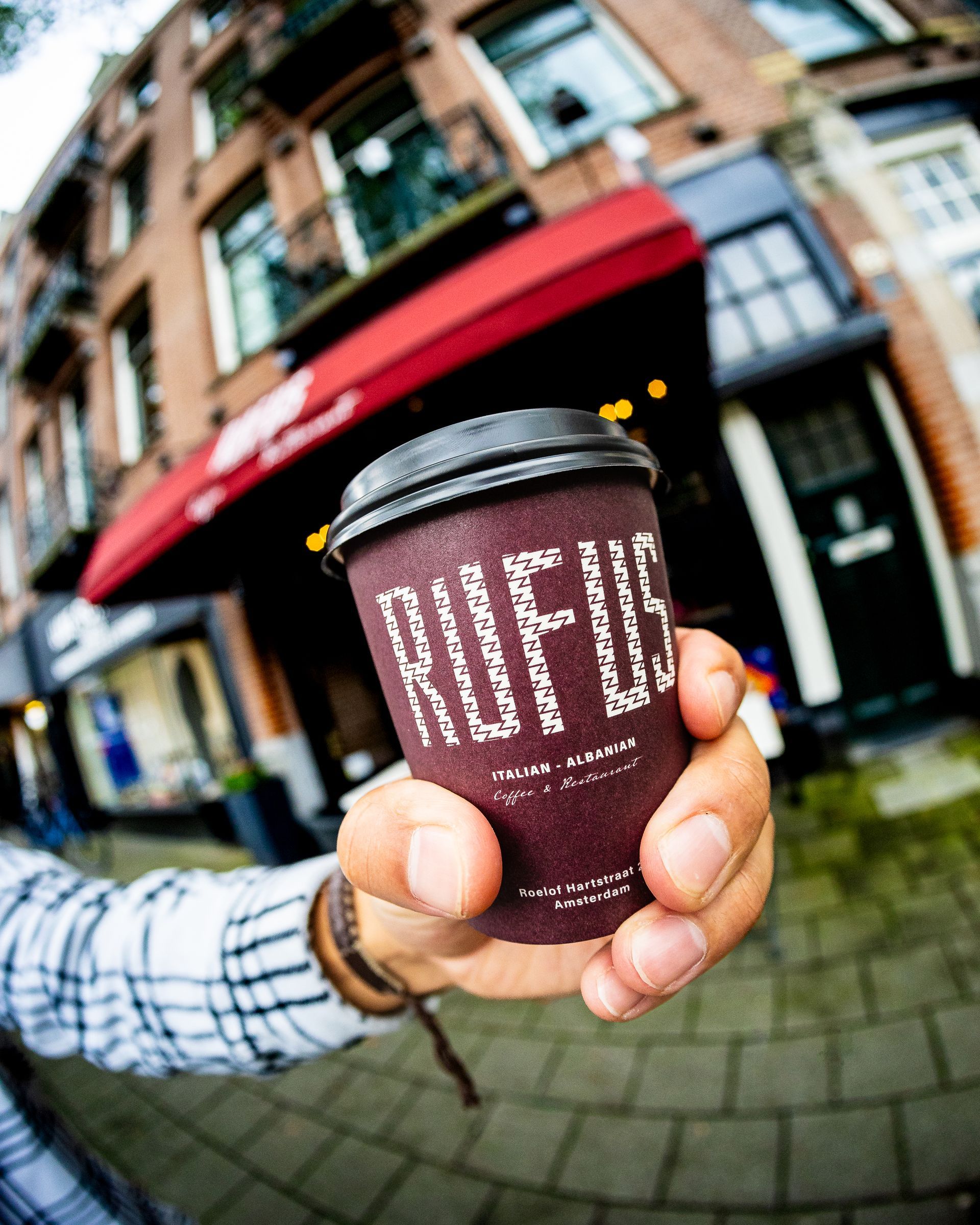 Hand die een koffiekopje vasthoudt, met daarop