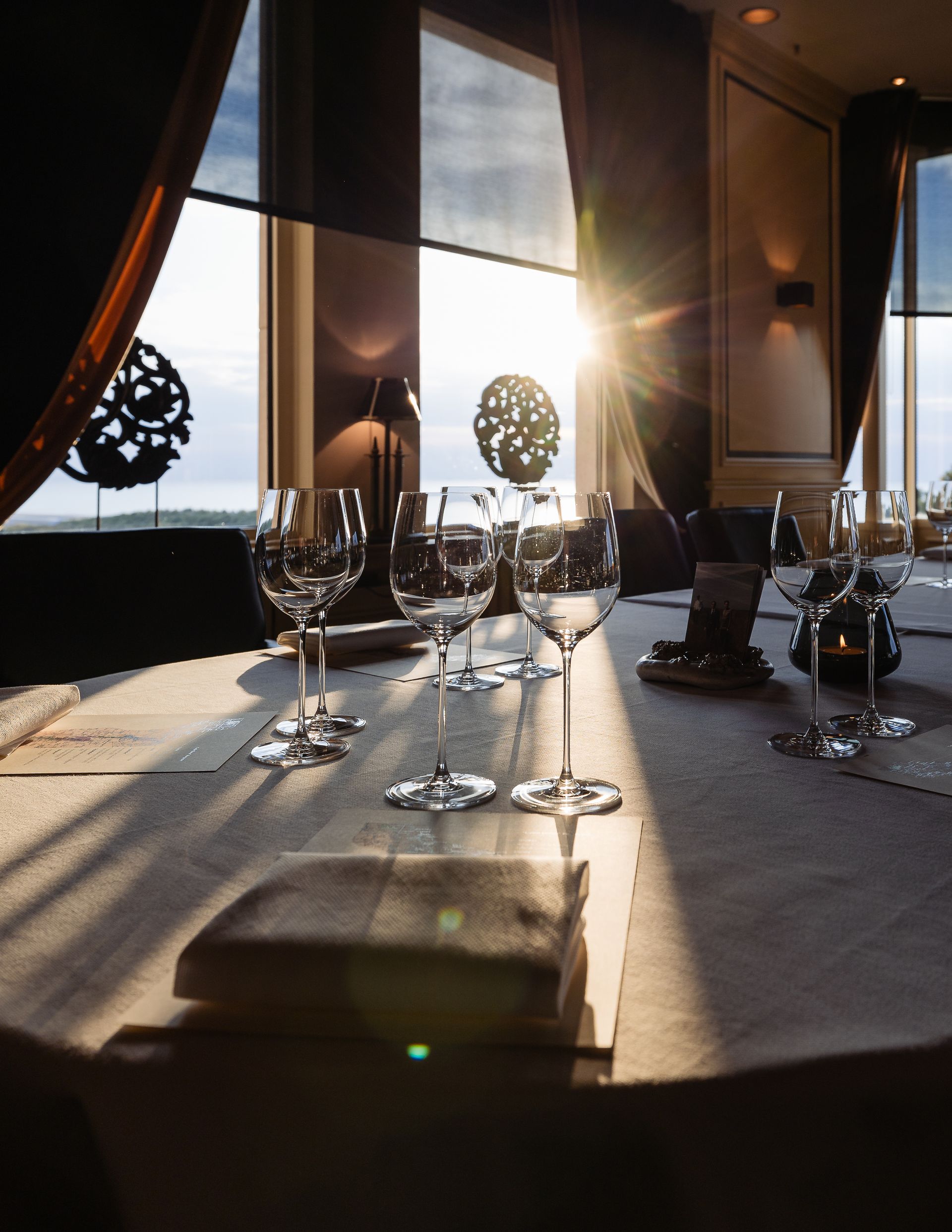 Restauranttafel gedekt om te dineren, met zonlicht dat door een raam naar binnen schijnt.
