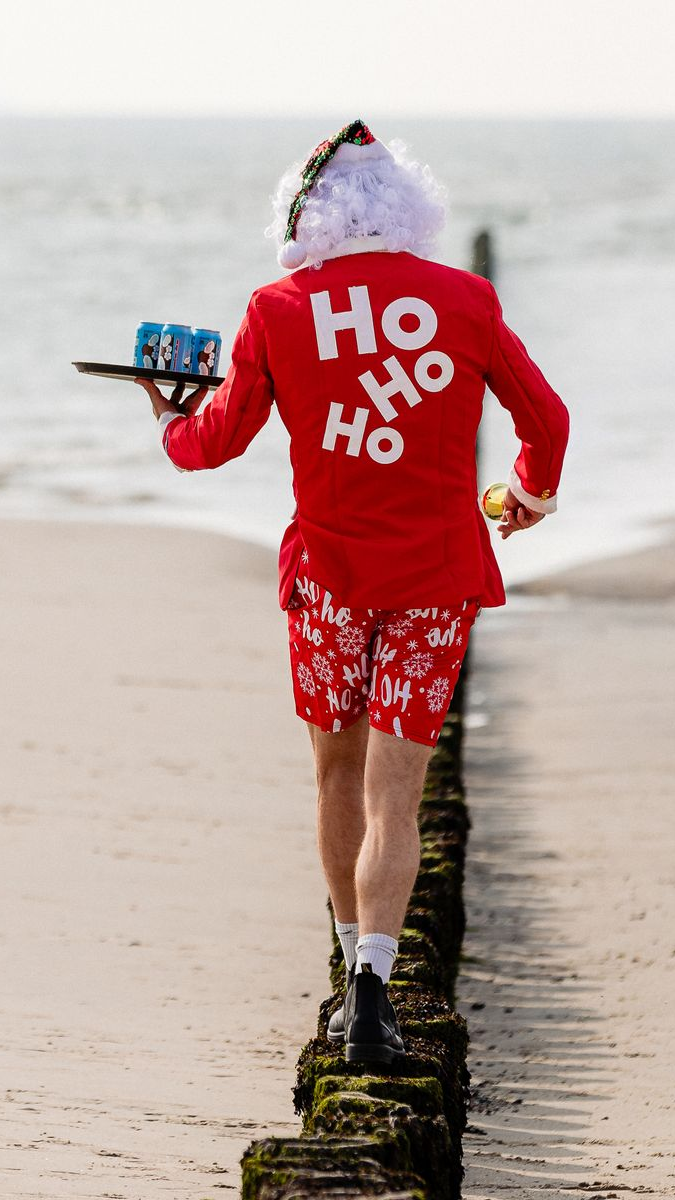 De kerstman, in een rood pak en korte broek met