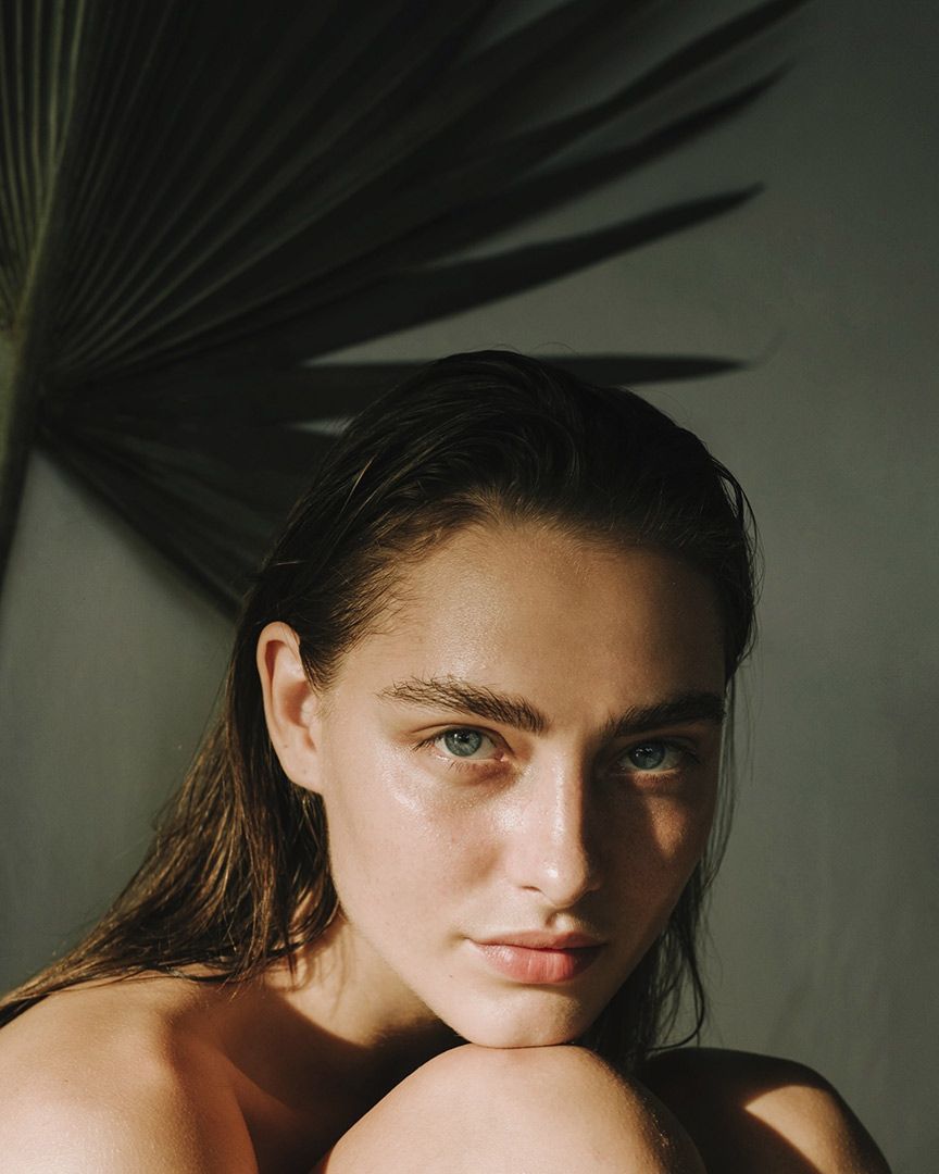 A Close Up Of A Woman's Face With A Palm Tree Leaf In The Background — Chez Belle Skin Care & Beauty Centre in Pimlico, QLD
