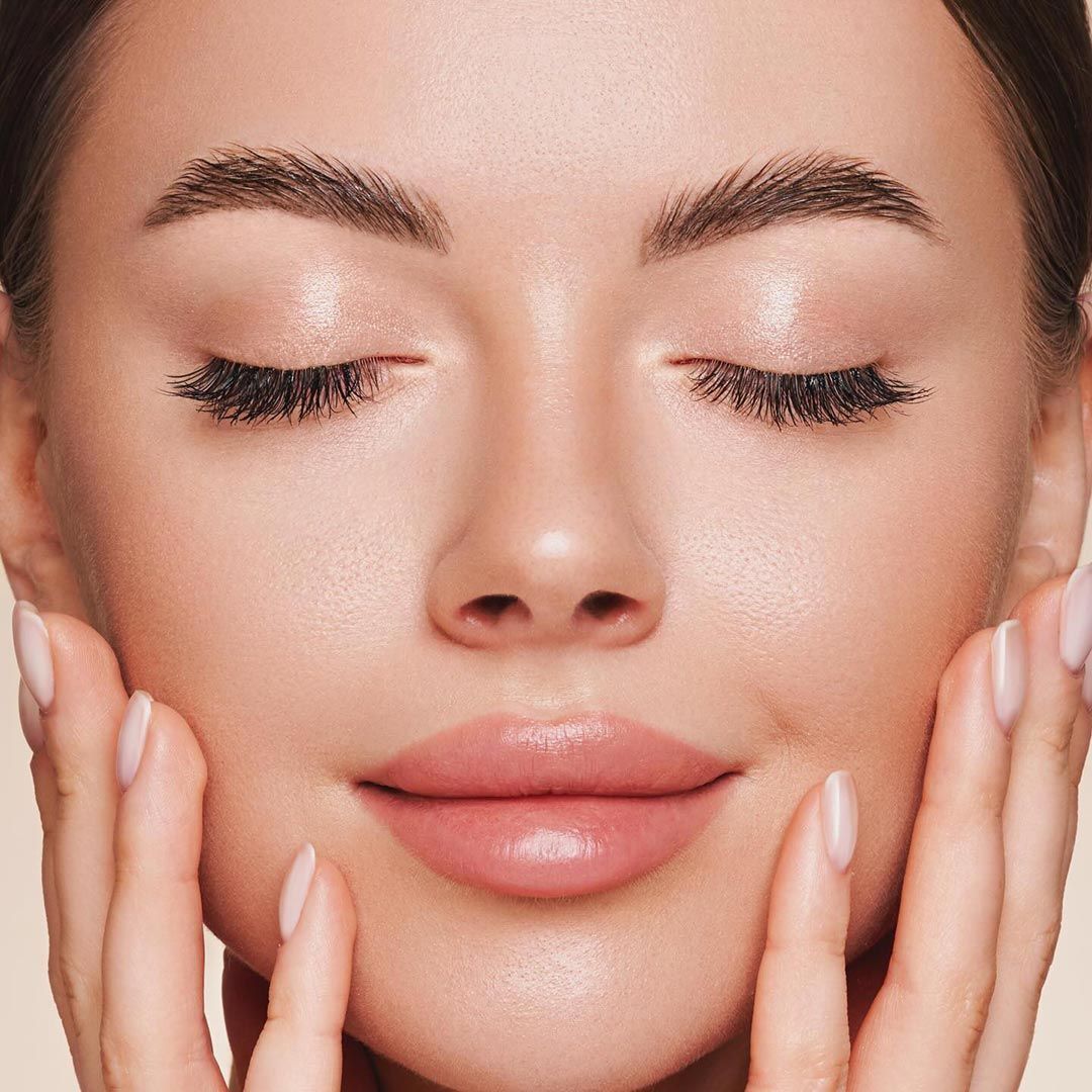 A Close Up Of A Woman's Face With Her Hands On Her Face — Chez Belle Skin Care & Beauty Centre in Pimlico, QLD