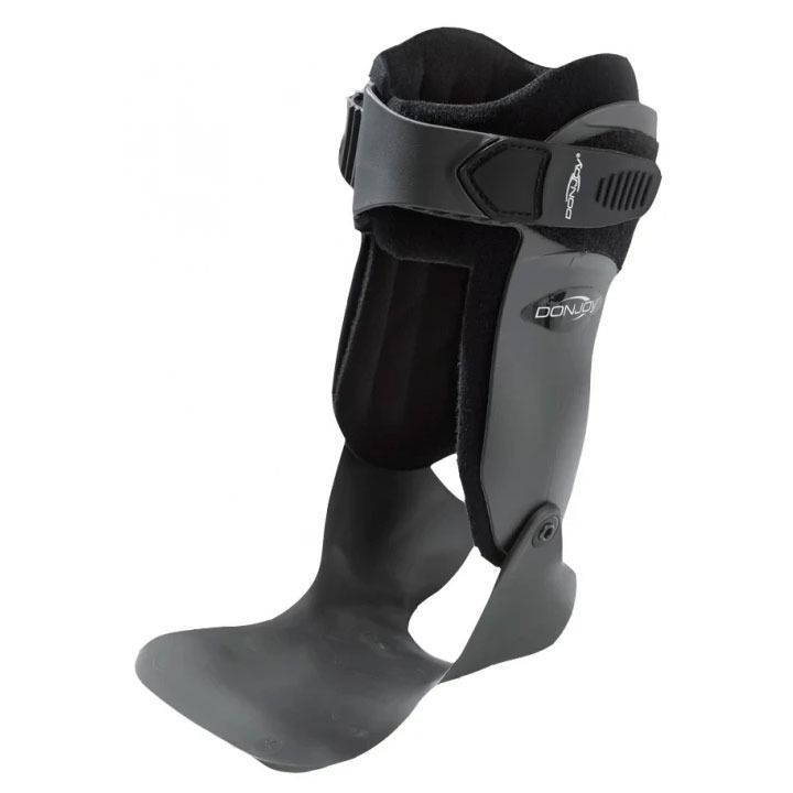 Black carbon-fiber prosthetic lower leg with foot and knee brace strap, isolated on white