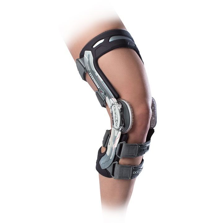 Knee brace with metal hinges and black straps on a bent leg