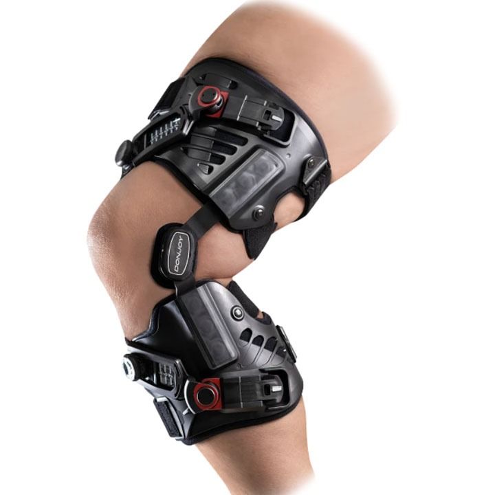 Black knee brace with hinged support worn on a bent leg