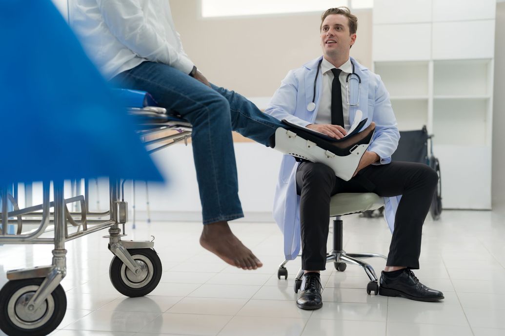 Doctor examining a patient’s injured foot in a bright clinic
