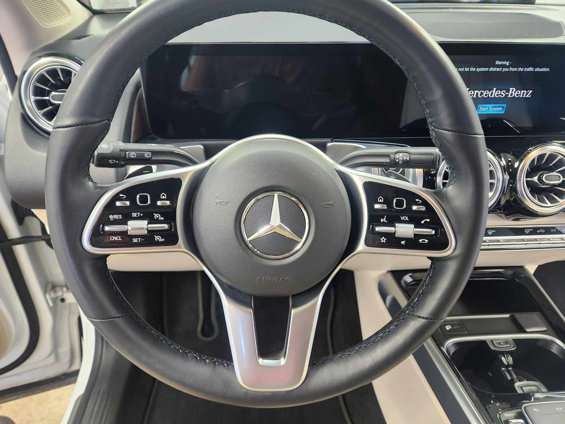 Mercedes-Benz steering wheel and dashboard interior view with digital display and silver accents