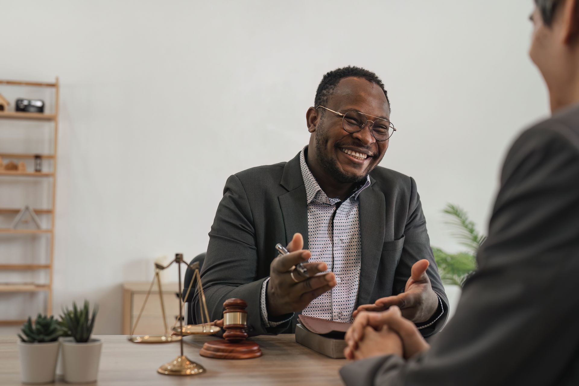 A man is sitting at a table talking to another man.