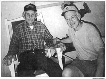 A black and white photo of two men sitting in chairs