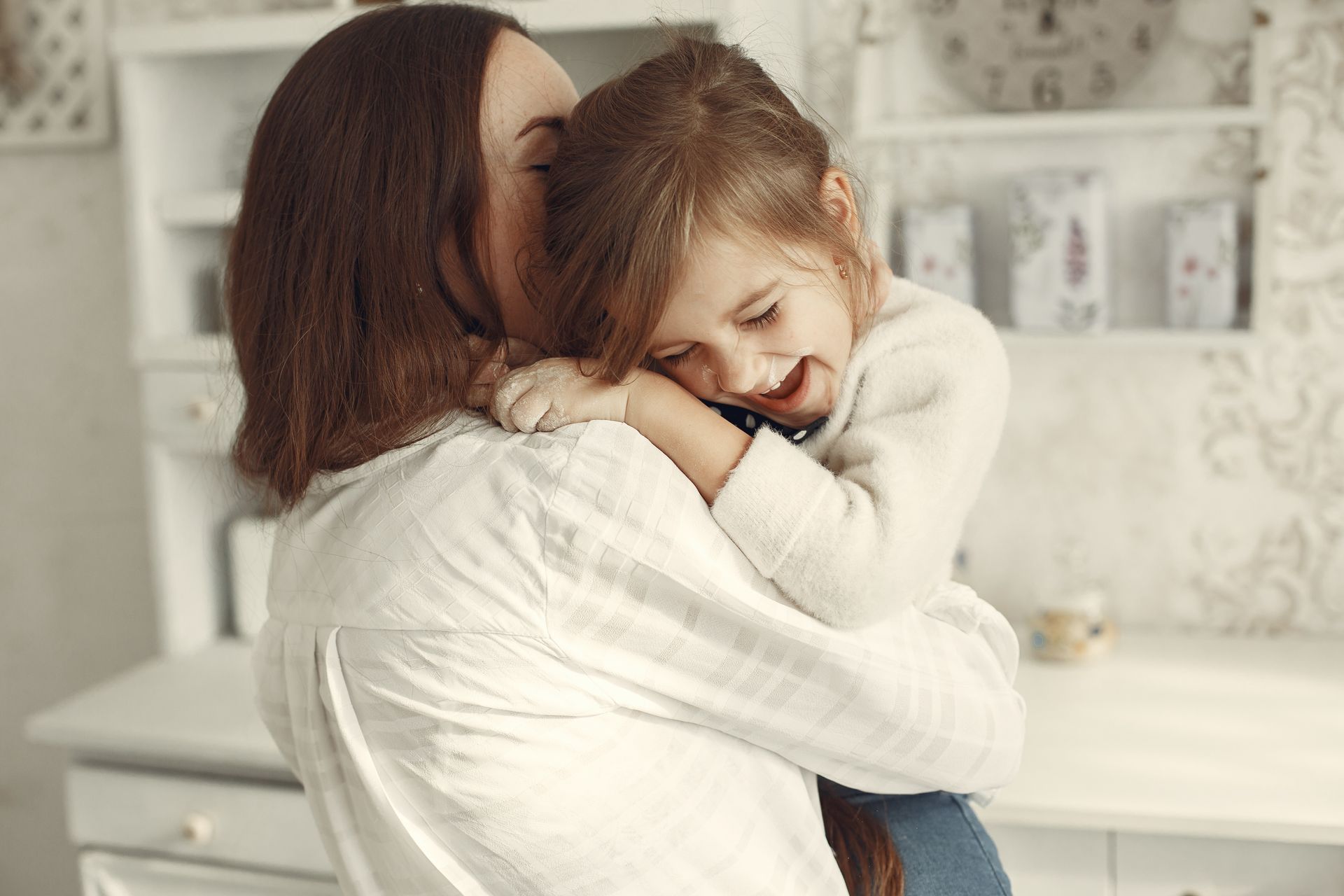 A woman is holding a little girl in her arms.