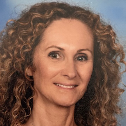 A woman is smiling for the camera while sitting on a set of stairs.