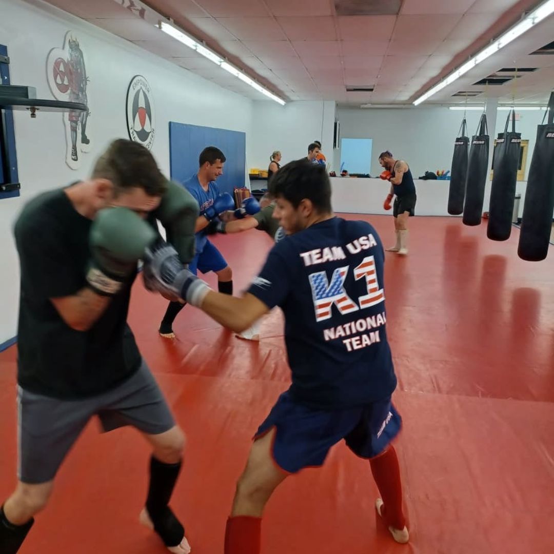 Two young men are practicing karate on a mat