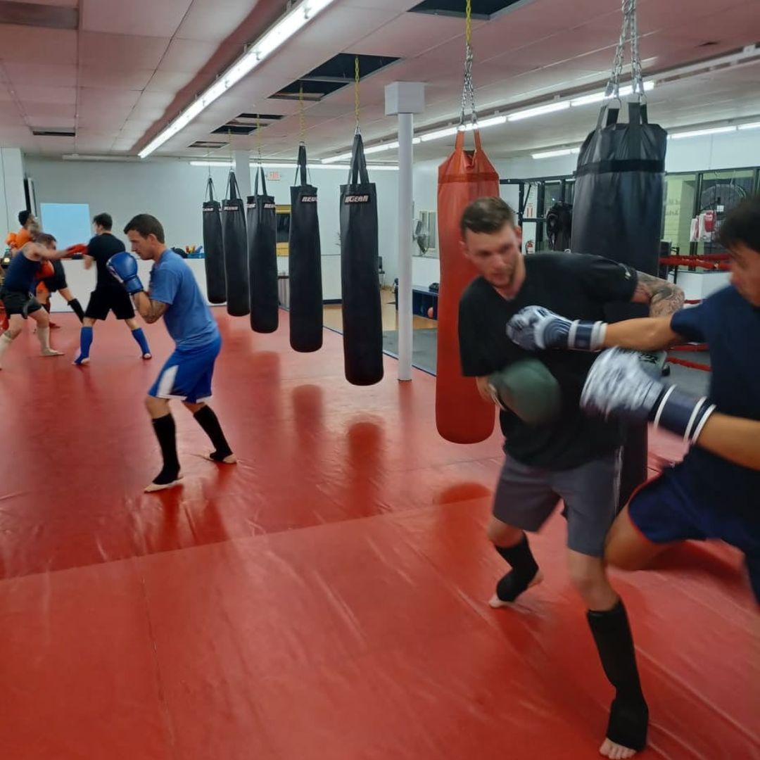 A group of men are practicing karate in a gym.