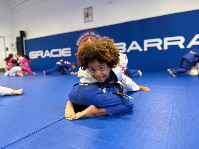 Children practicing grappling on blue mats in Gracie Barra Sienna dojo in Fresno, TX
