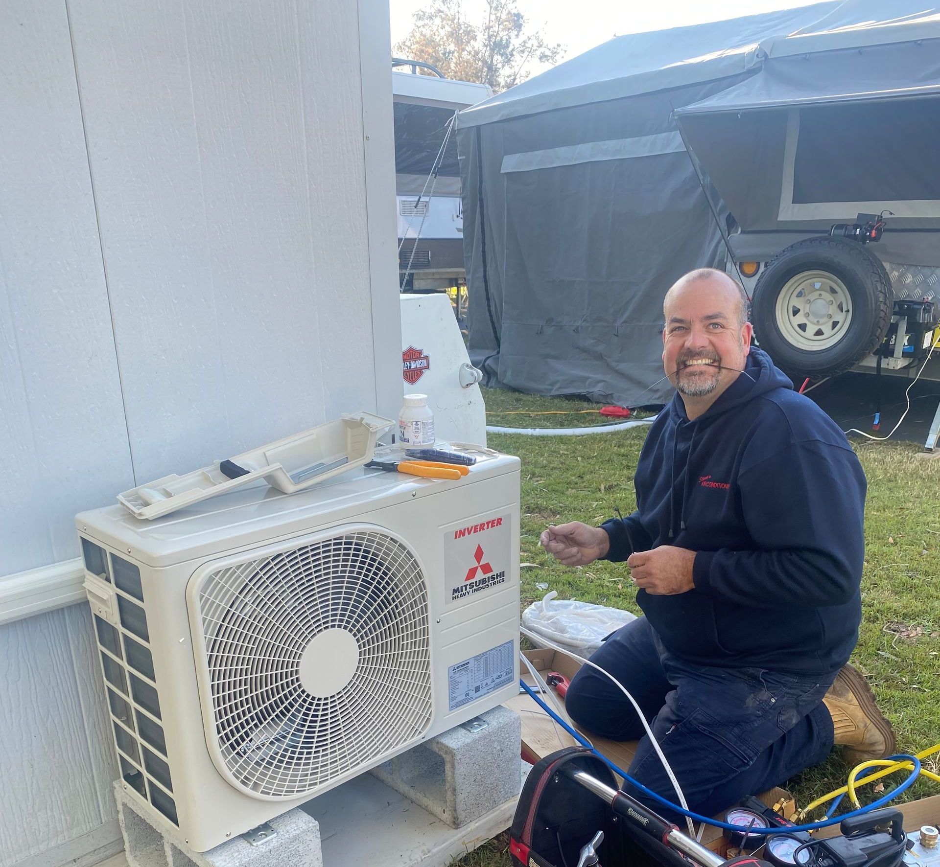 A Man is Working on an Air Conditioner With a Wrench — Steve's Air Conditioning in Windang, NSW