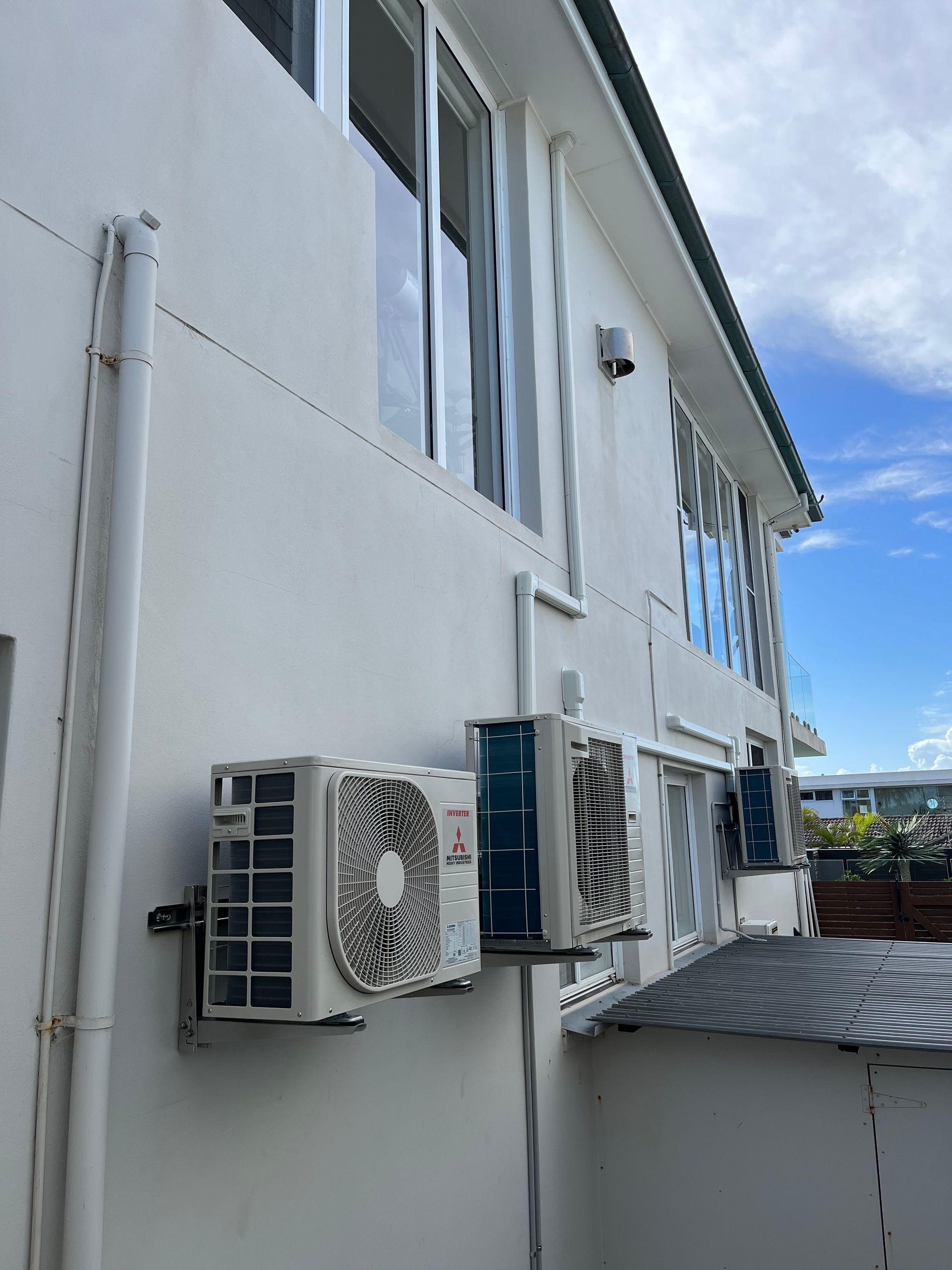 A white building with a lot of air conditioners on it