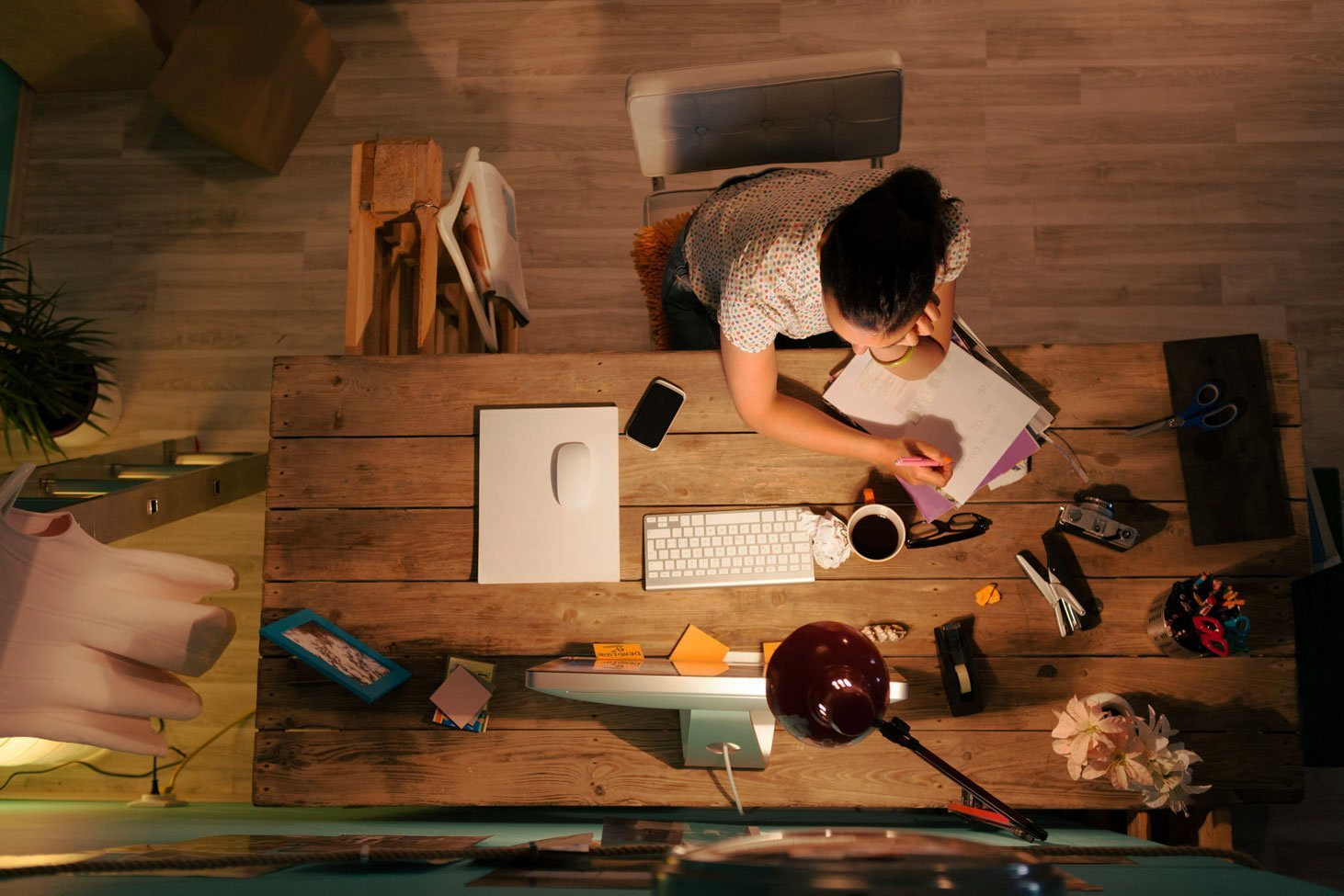 Moça sentada na mesa lendo por que não deve fazer o marketing digital por conta