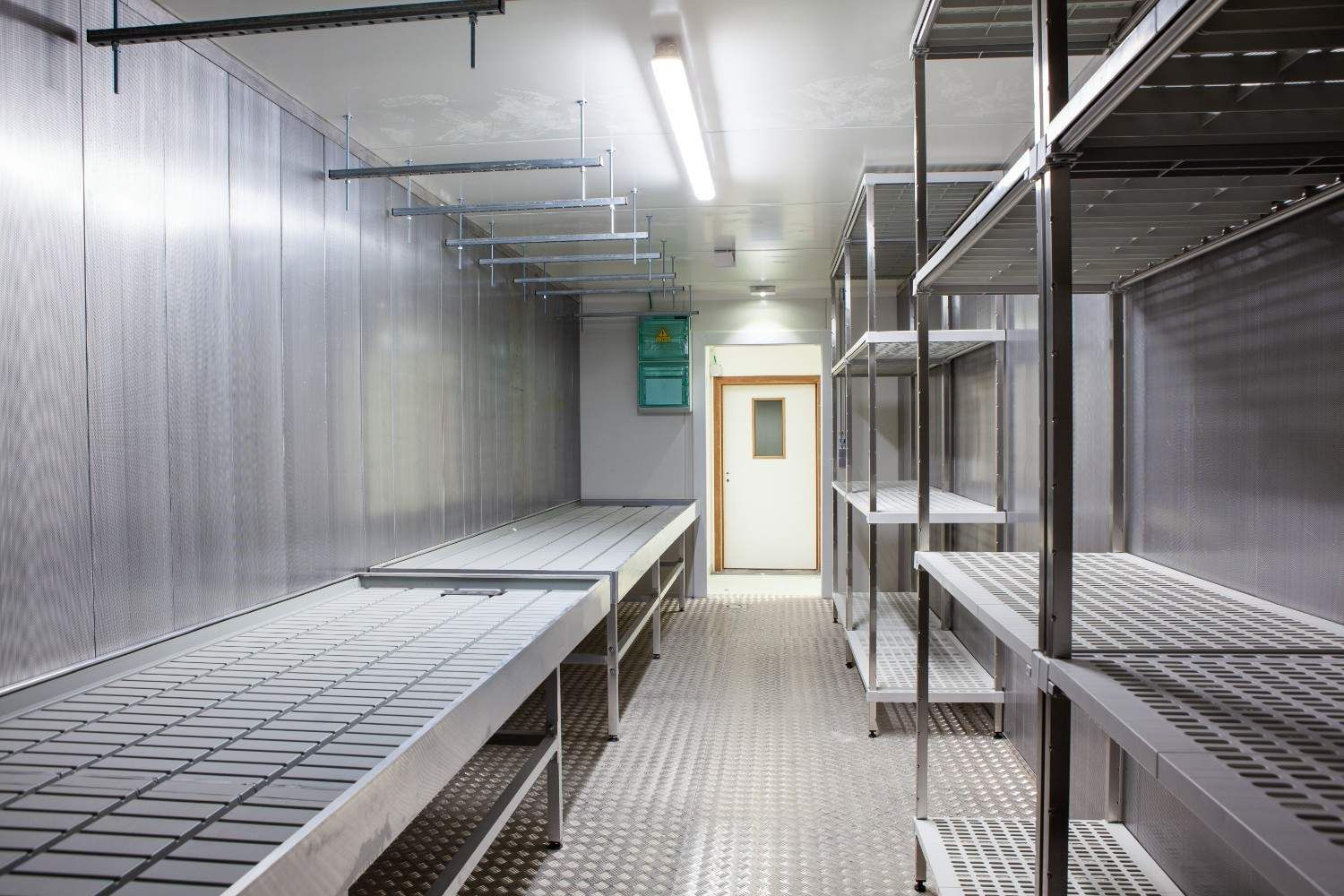 Empty industrial walk-in cooler with metal shelving — Magneto HVAC in Portsmith, QLD