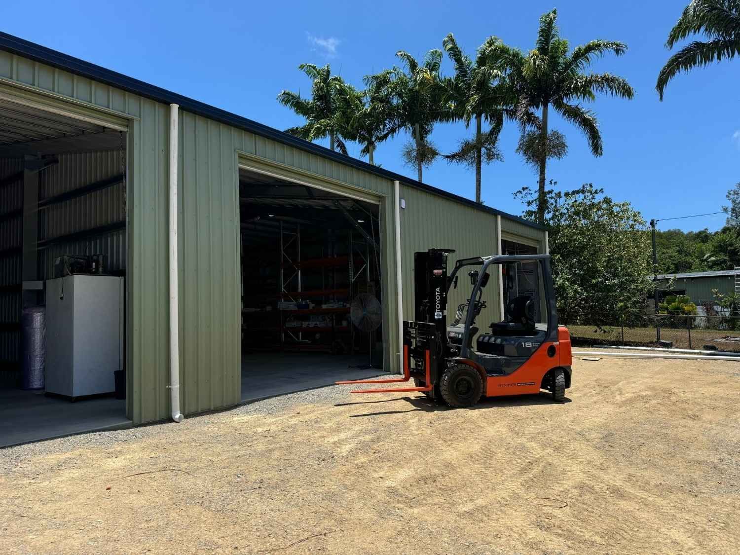 Orange forklift parked outside an open warehouse — Magneto HVAC in Portsmith, QLD