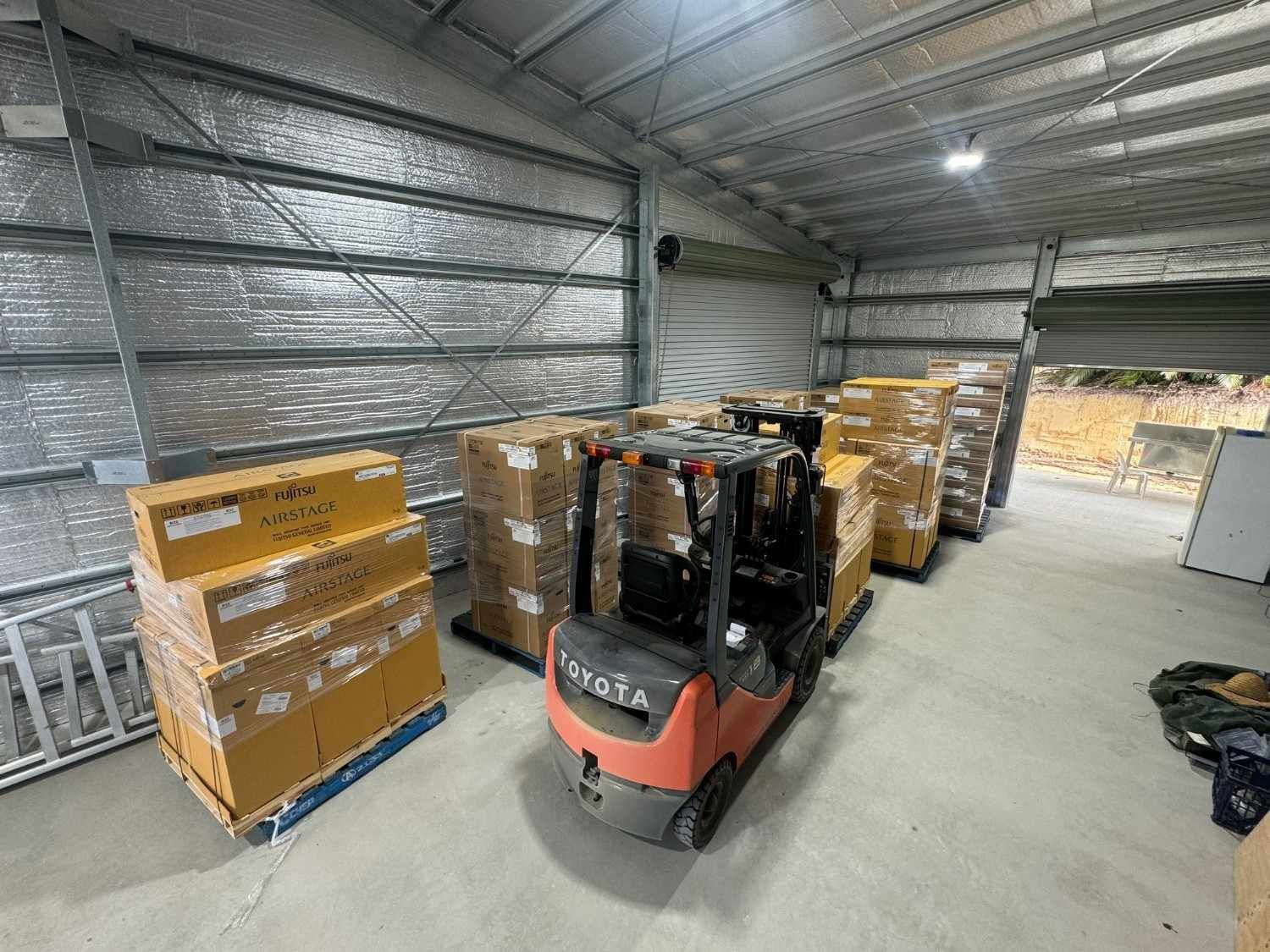 A Forklift Loading Pallets of Cardboard Boxes Inside a Warehouse — Magneto HVAC in Cape York, QLD