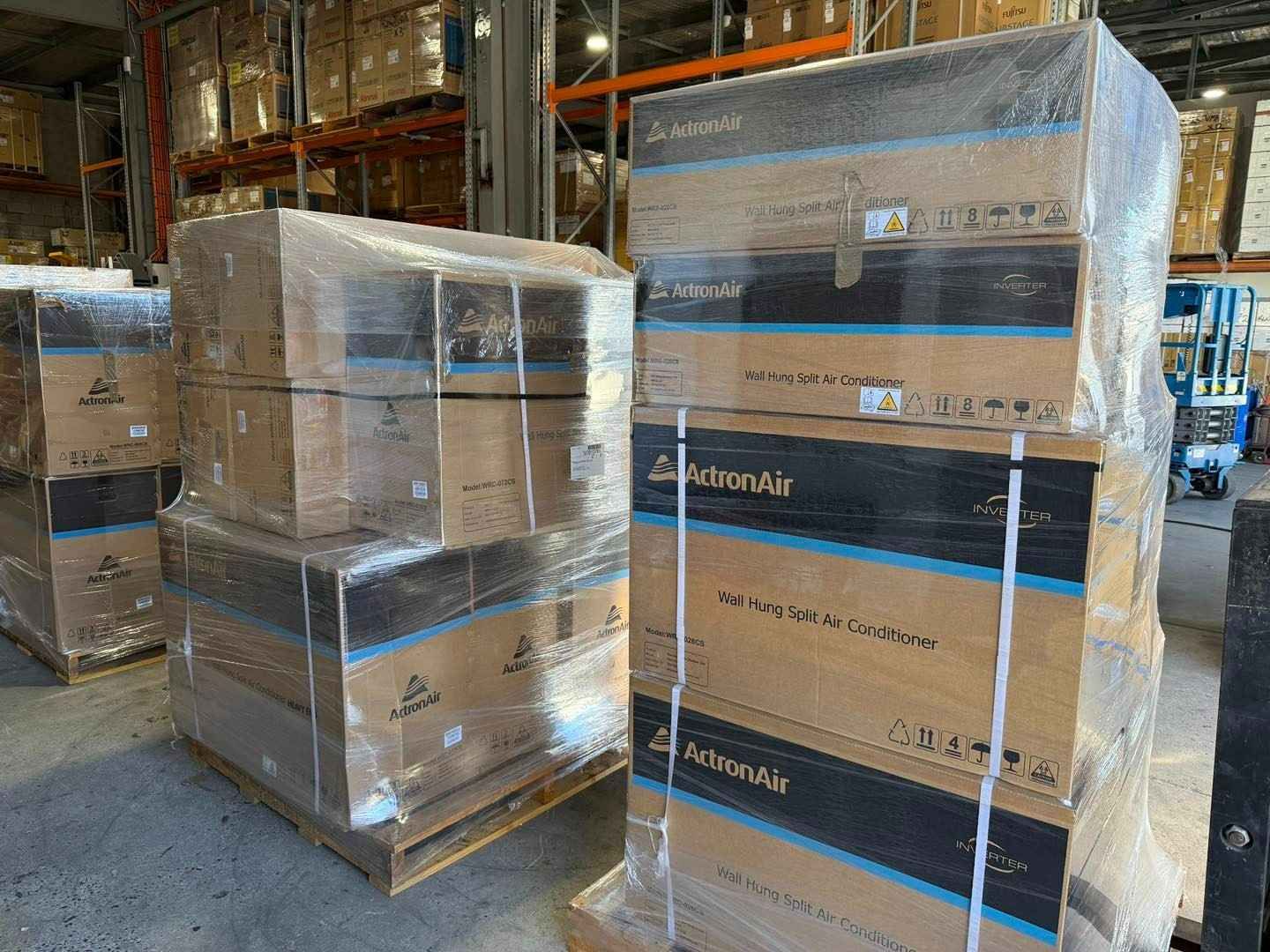 Pallets of Cardboard Boxes Wrapped in Plastic in A Warehouse — Magneto HVAC in Portsmith, QLD