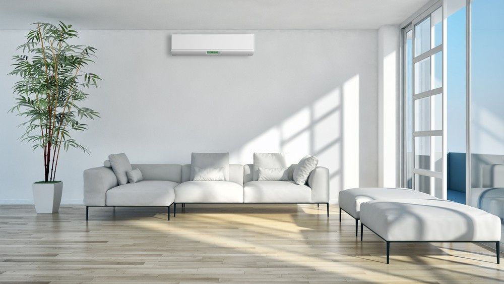 An Air Conditioner Above the Sofa in A Living Room — Magneto HVAC in Cardwell, QLD