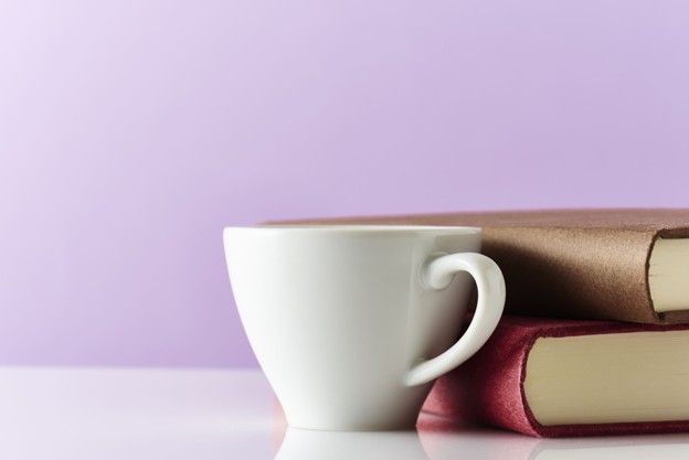 Coffee cup next to two books