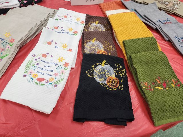 Assorted colorful towels laid out on a red surface.