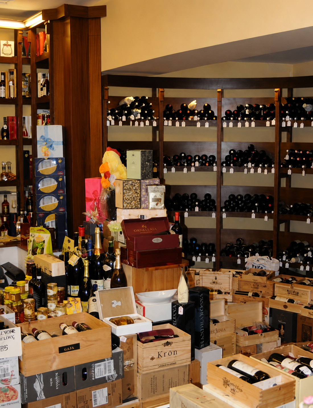 Bottiglie di vino impilate in scatole di cartone sugli scaffali di un negozio che ricorda una cantina.