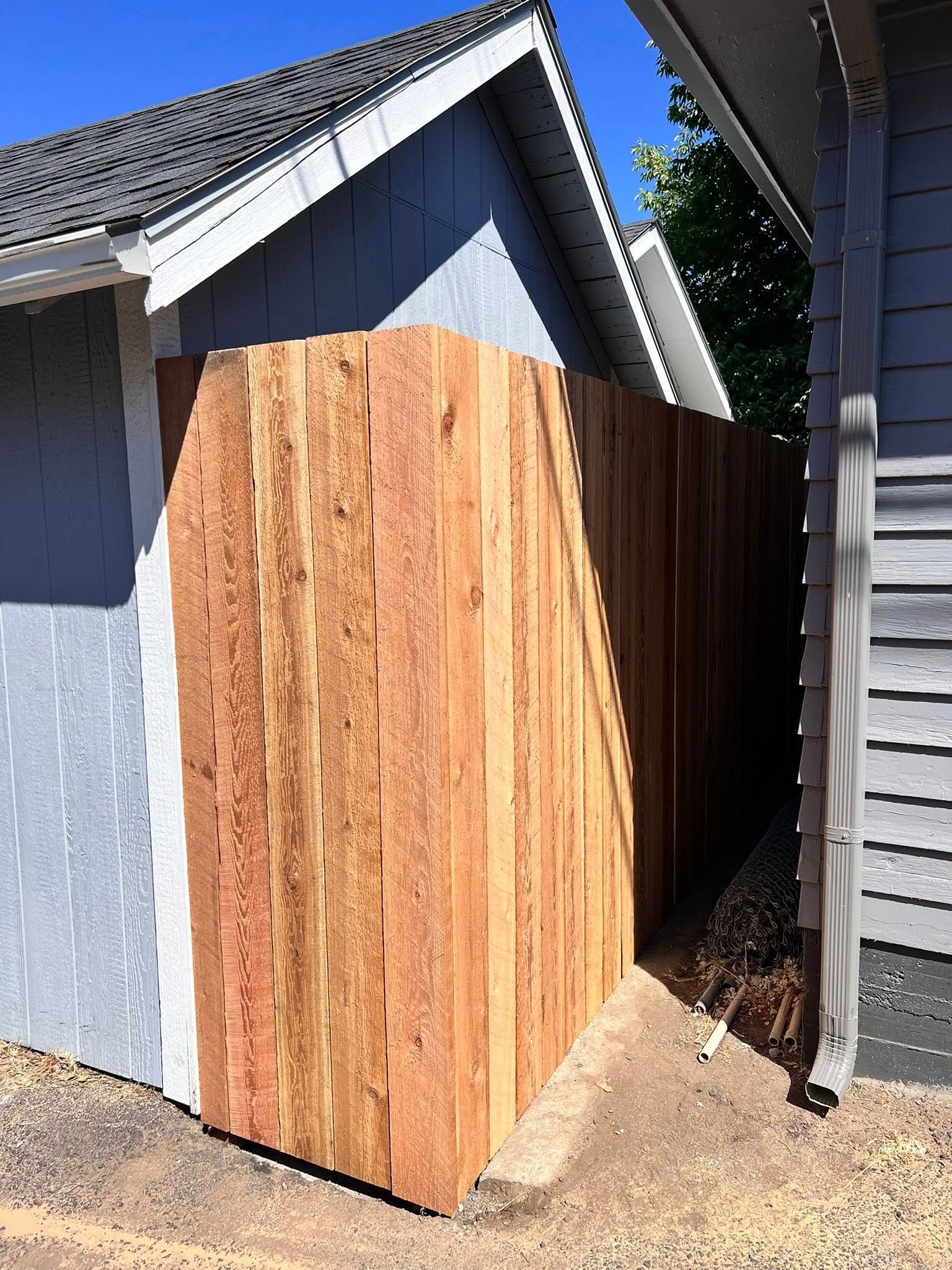 Wooden fence constructed next to two buildings.