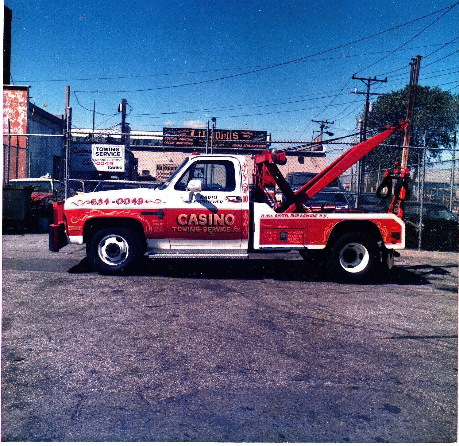Red and white CASINO tow truck parked in a lot under a blue sky