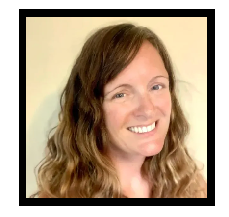 A woman with long curly hair is smiling for the camera.