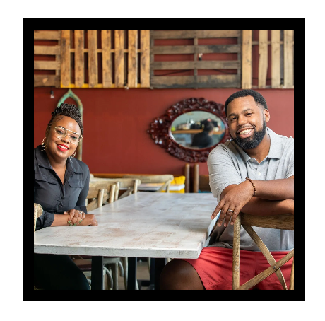 A man and a woman are sitting at a table in a restaurant.