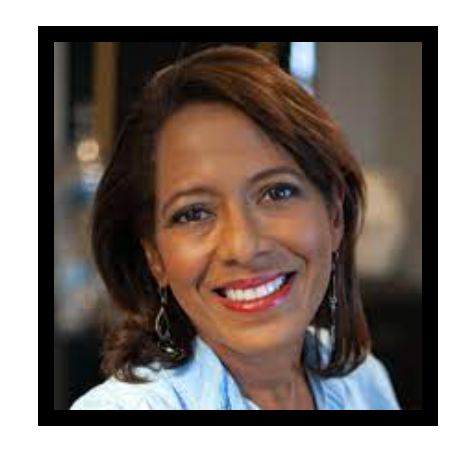 A woman wearing a blue shirt and red lipstick is smiling for the camera.