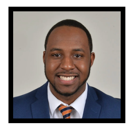 A man in a suit and tie is smiling for the camera