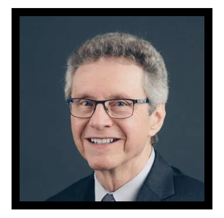 A man in a suit and tie is smiling for the camera.