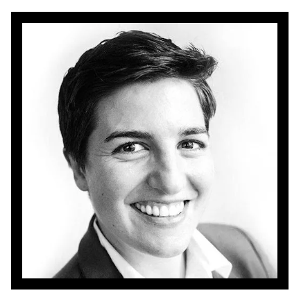 A woman with short hair is smiling in a black and white photo.