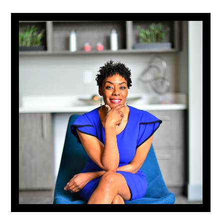 A woman in a blue dress is sitting in a blue chair with her legs crossed.