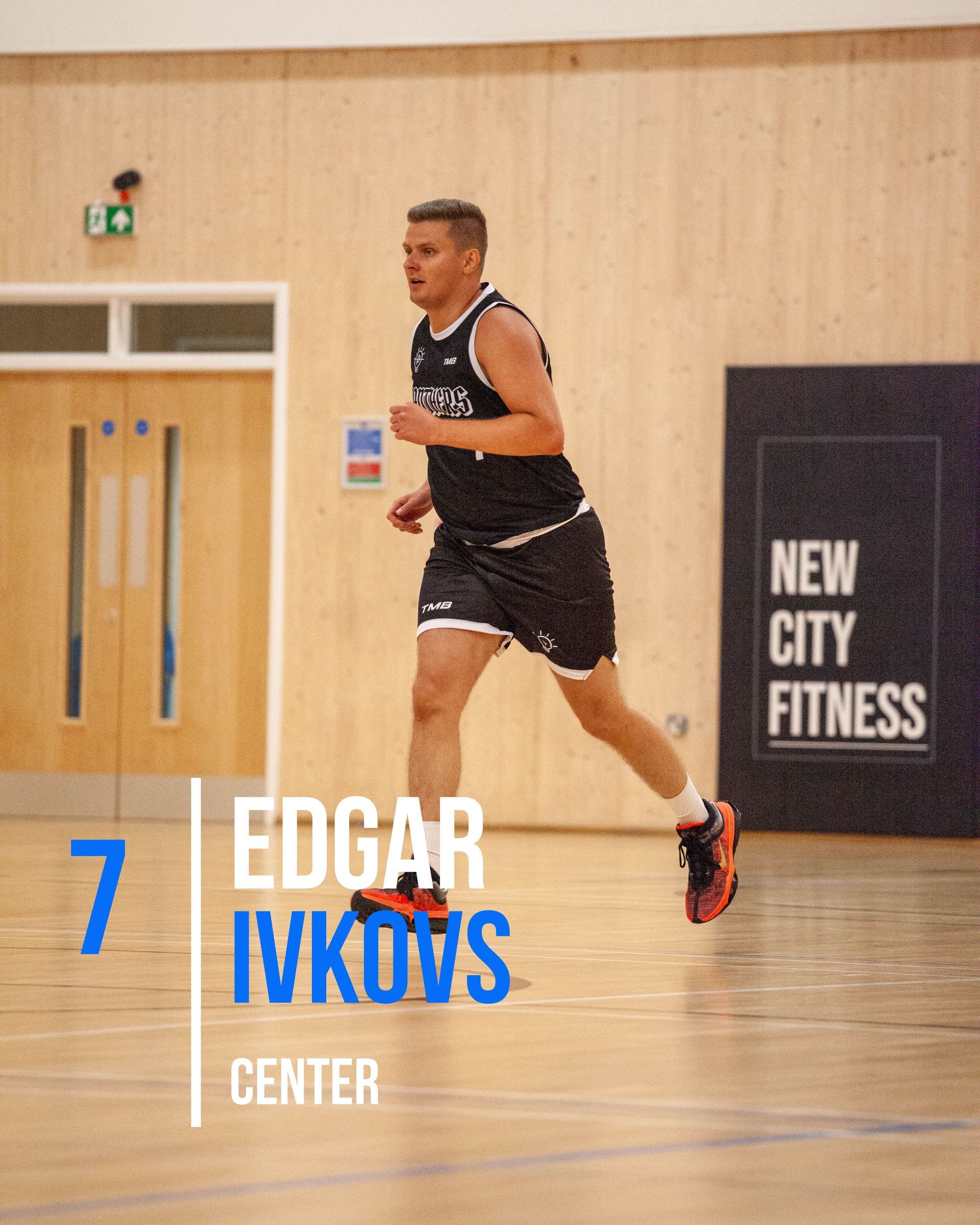 Basketball player Edgar Ivkovs running on a court. He wears a black jersey and shorts, number 7.