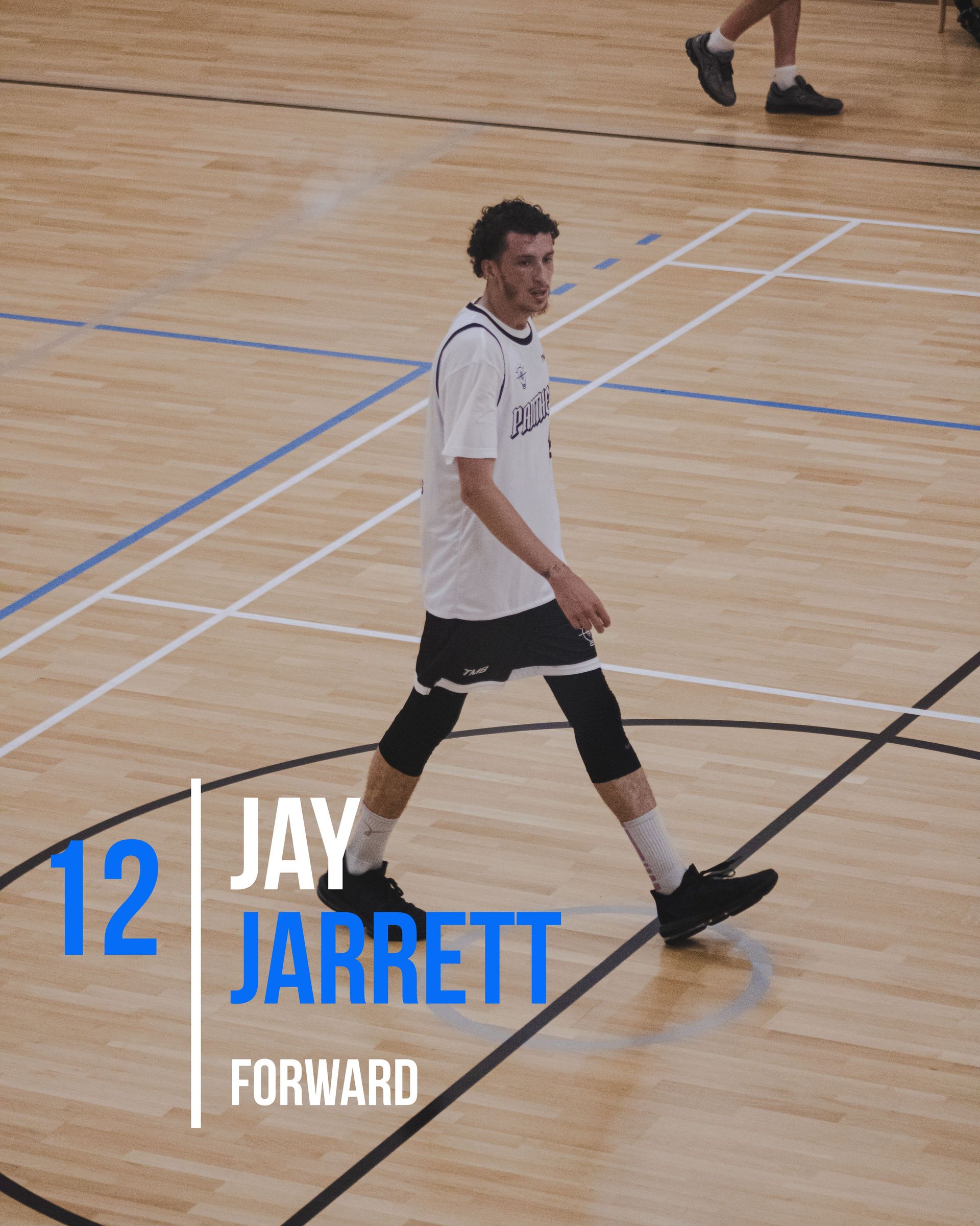 Basketball player Jay Jarrett walking on a court, wearing white jersey, black shorts, and a knee brace.