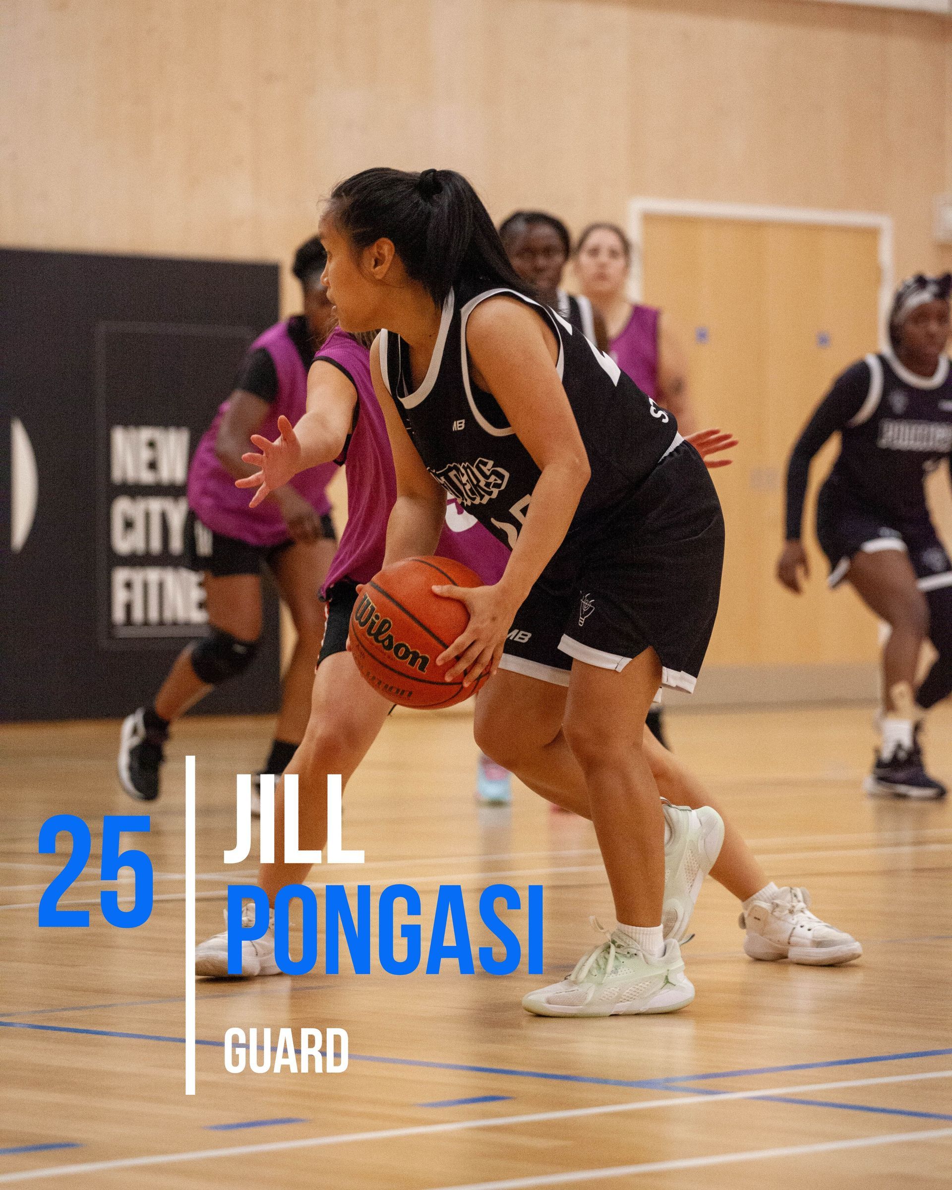 Basketball player Kiera Williams in a blue uniform, holding the ball, preparing to play on the court.