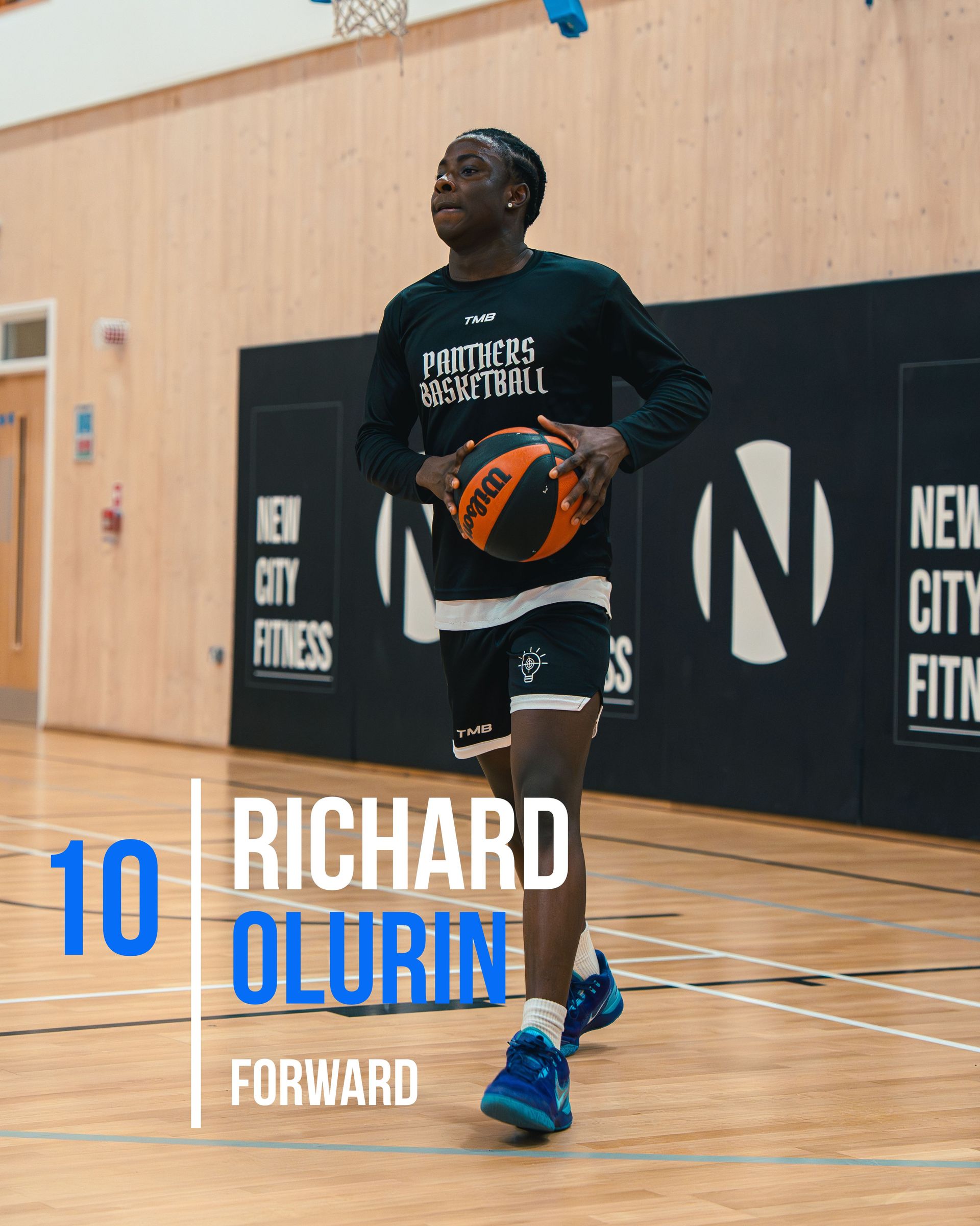 Basketball player Richard Olurin in uniform, holding a ball in a gym.
