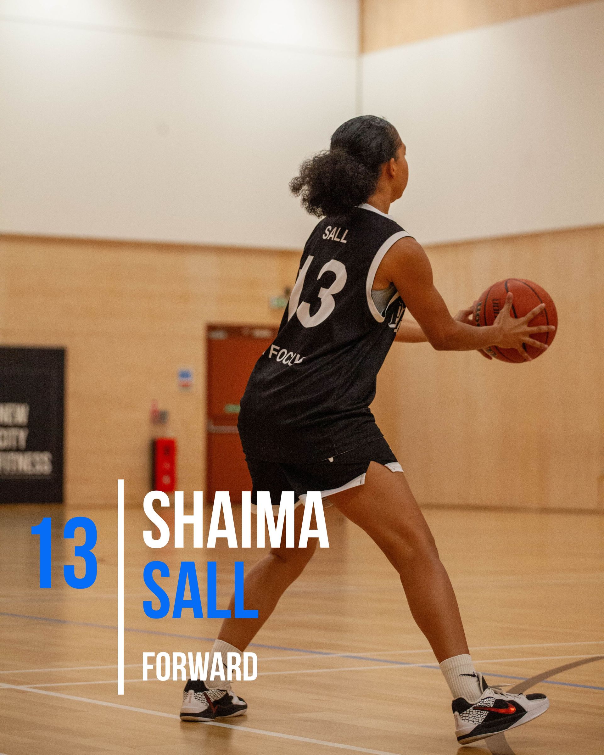 Basketball player Kiera Williams in a blue uniform, holding the ball, preparing to play on the court.