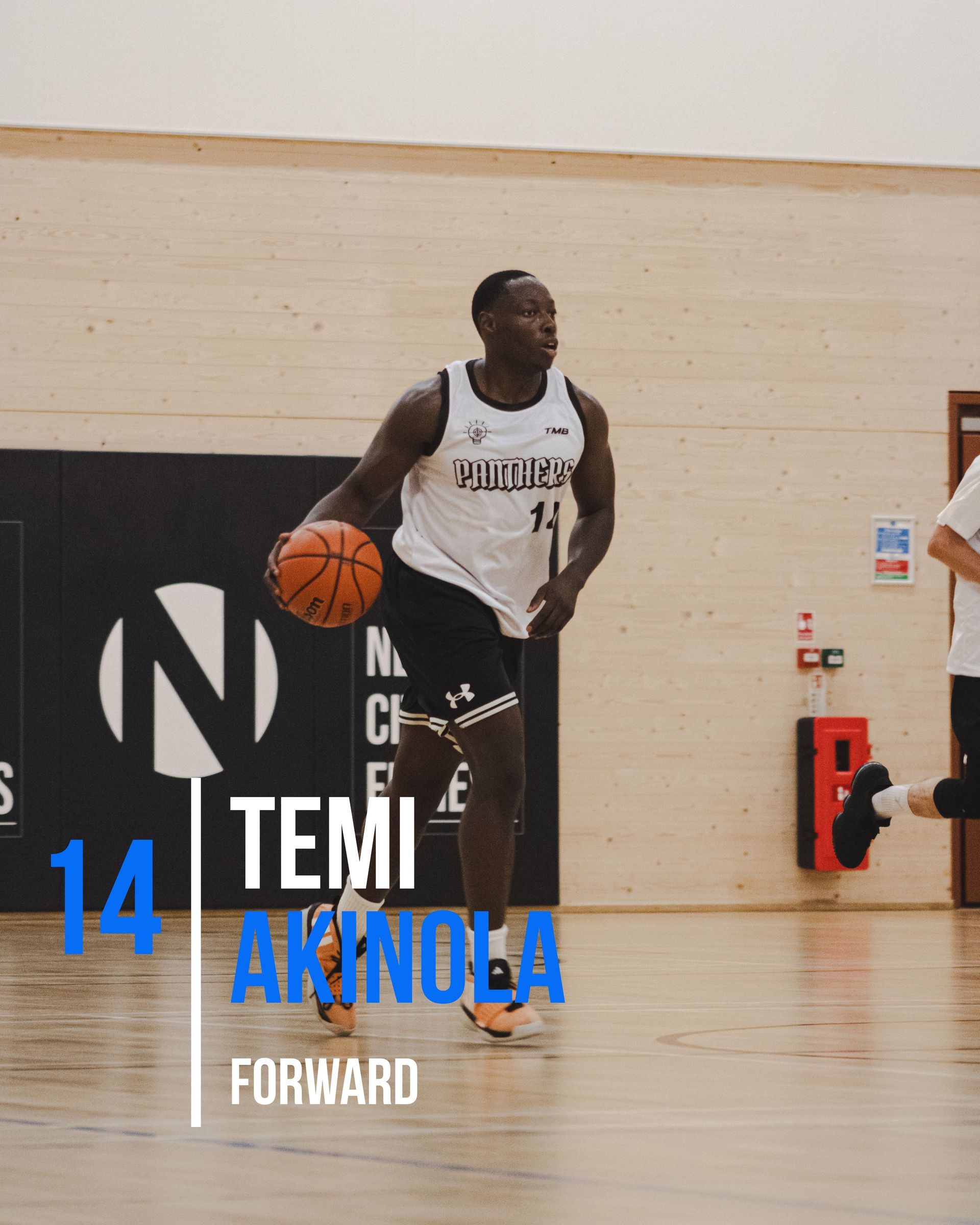 Basketball player dribbling a ball. Number 14 Temi Akinola, forward. Court setting.