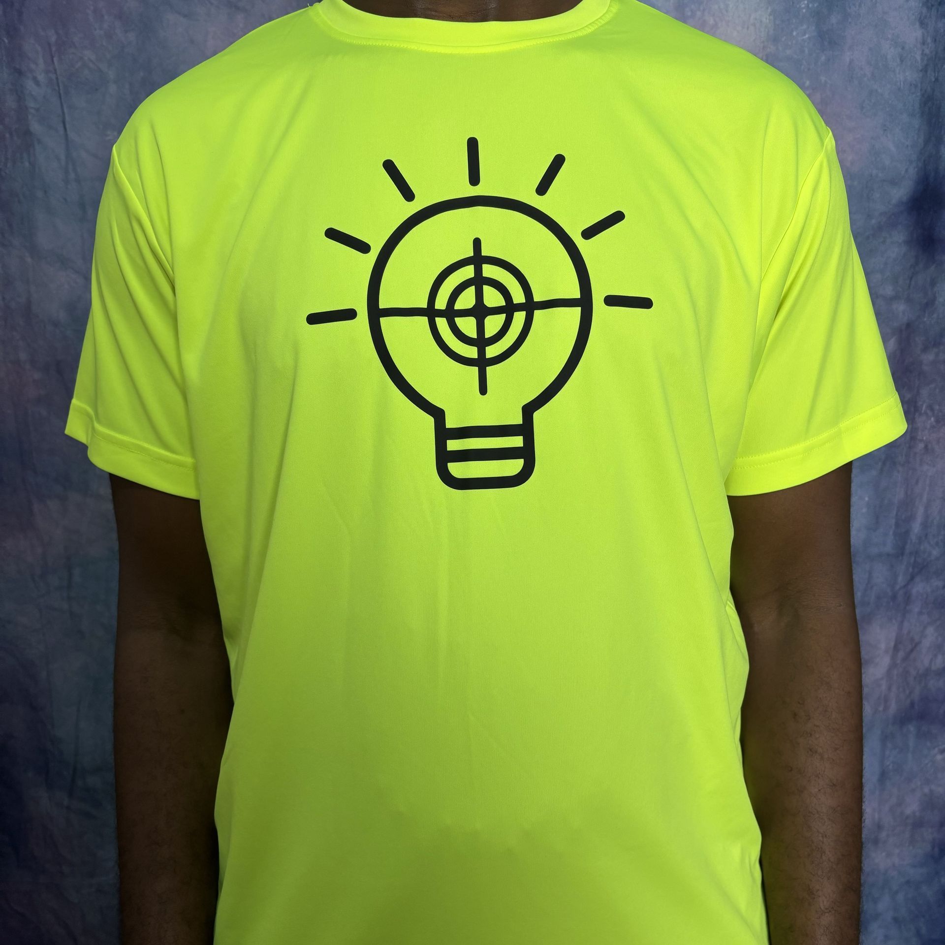 Bright yellow t-shirt with a black lightbulb design containing a target symbol.