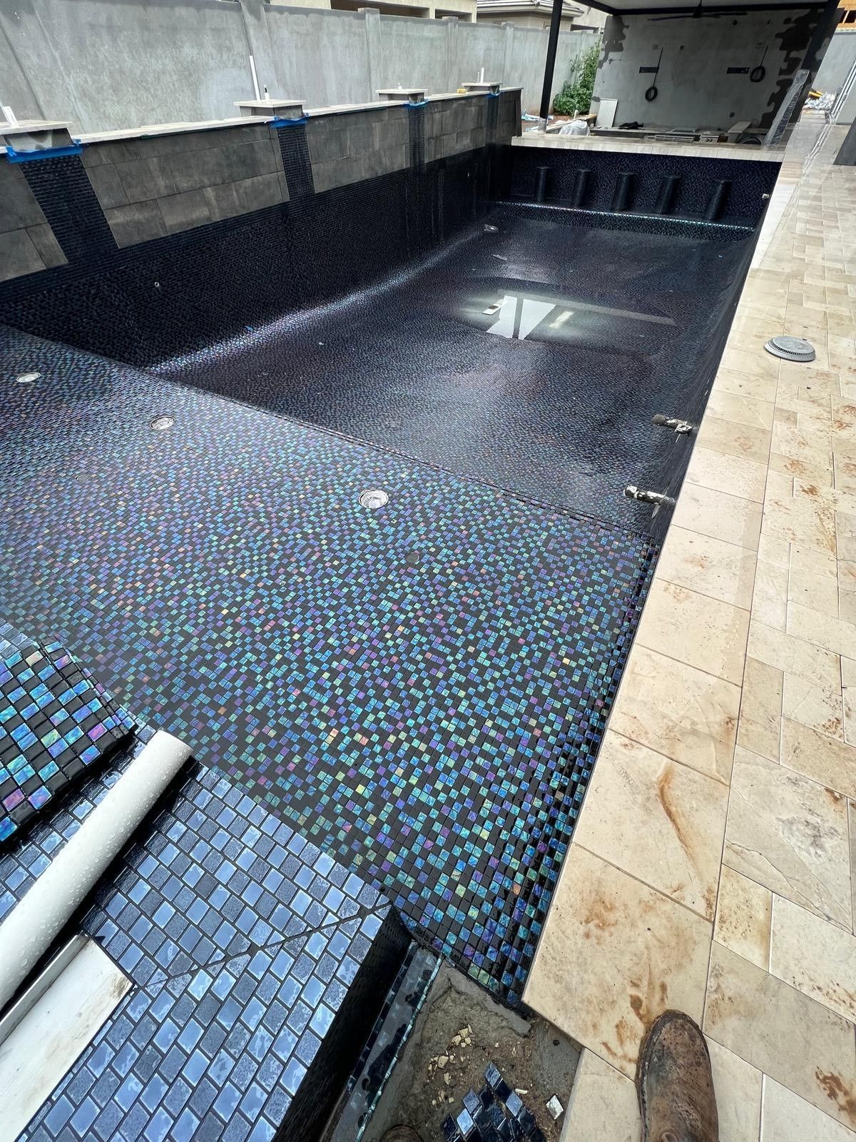 A large swimming pool is being built in a backyard.