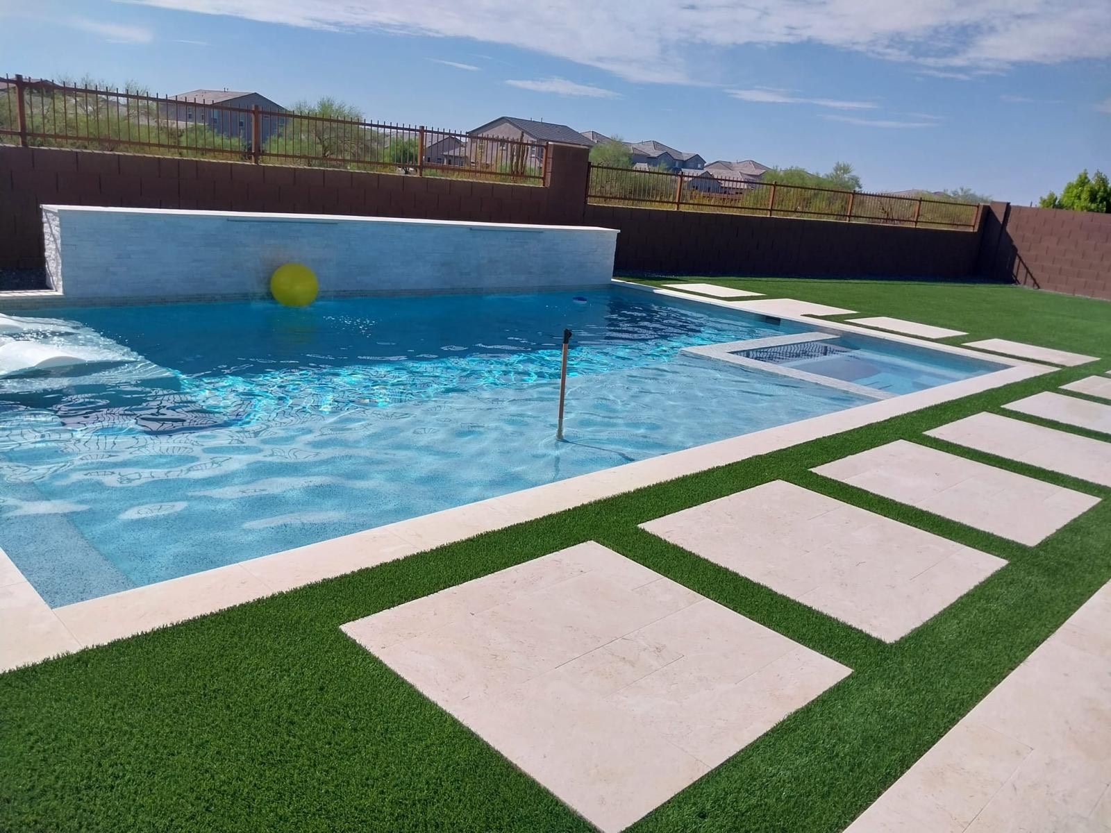 A large swimming pool with a yellow ball in it