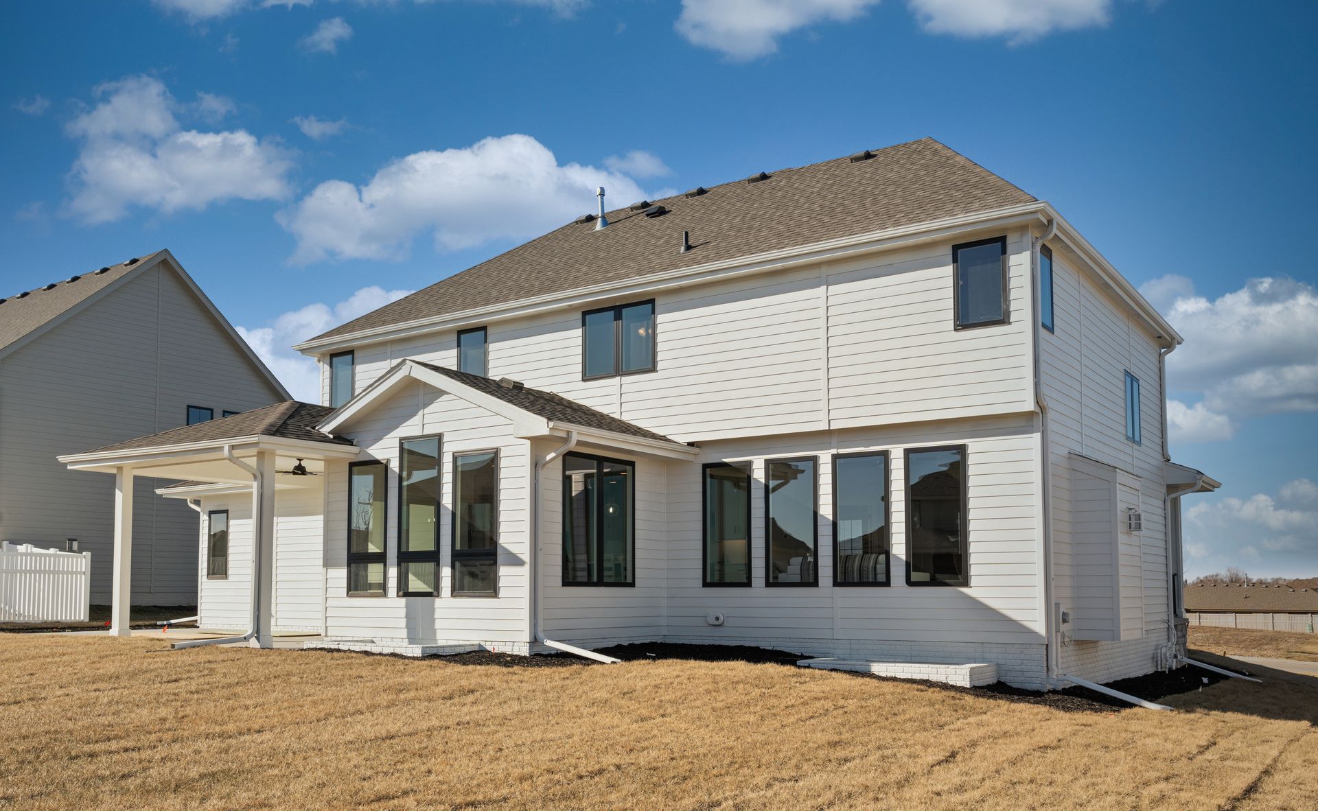New white two-story house with covered patio in a newly built neighborhood